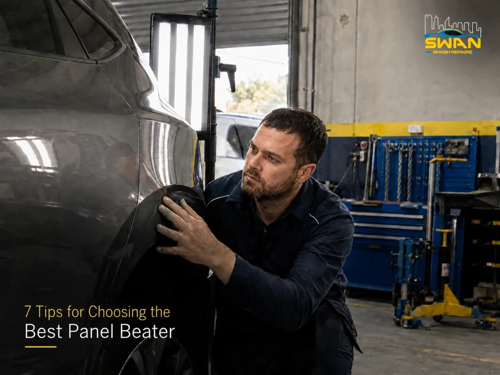 Panel beater inspecting a repaired car panel in a professional Perth workshop.